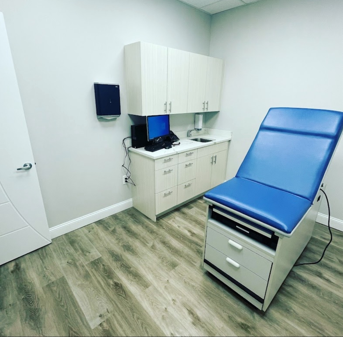Clean medical exam room with spotless flooring and cabinetry
